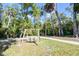 Relaxing outdoor swing offers a peaceful escape with views of the lush greenery and tranquil pond at 5360 Riverwalk Preserve Dr, New Port Richey, FL 34653