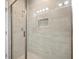Stylish bathroom showcasing a glass-enclosed shower with neutral tile, built-in niche, and modern fixtures at 5360 Riverwalk Preserve Dr, New Port Richey, FL 34653