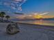 A beautiful beachfront sunset with palm trees offers a tranquil Gulf Harbors waterfront view at 5557 Sea Forest Dr # 318, New Port Richey, FL 34652
