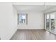 Bright bedroom featuring wood-look flooring, window, and balcony access at 5557 Sea Forest Dr # 318, New Port Richey, FL 34652