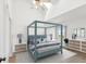 Well-decorated bedroom with a modern four-poster bed, high ceiling, and hardwood floors at 5557 Sea Forest Dr # 318, New Port Richey, FL 34652