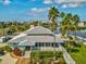 Exterior of the Gulf Harbors community clubhouse featuring lush landscaping, a metal roof, and waterfront access at 5557 Sea Forest Dr # 318, New Port Richey, FL 34652