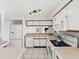 Kitchen with white appliances, light countertops, white cabinets, and a breakfast bar at 5557 Sea Forest Dr # 318, New Port Richey, FL 34652