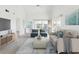 Bright living room with high ceilings, gray wood floors, comfortable seating, and access to the outdoor balcony at 5557 Sea Forest Dr # 318, New Port Richey, FL 34652