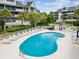 Bright community pool area with plentiful lounge chairs and a charming poolside cabana in a tropical community at 5557 Sea Forest Dr # 318, New Port Richey, FL 34652