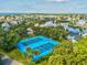 An aerial view of well maintained blue tennis courts in a vibrant Gulf Harbors community with lush greenery at 5557 Sea Forest Dr # 318, New Port Richey, FL 34652