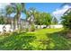 Landscaped backyard featuring healthy green lawn and privacy fence with tropical foliage at 5737 Wynstone Ln, Zephyrhills, FL 33541