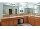 Bright bathroom with double sinks, large mirror, and wooden cabinets provide ample storage at 5737 Wynstone Ln, Zephyrhills, FL 33541