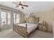 Cozy bedroom with carpet, ceiling fan, and a large bed with decorative headboard at 5737 Wynstone Ln, Zephyrhills, FL 33541