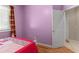 Small bedroom with wood floors, pink walls, and a closed closet at 5737 Wynstone Ln, Zephyrhills, FL 33541