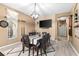 Well-lit dining area features modern lighting, hardwood floors, and entertainment features at 5737 Wynstone Ln, Zephyrhills, FL 33541