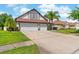 Expansive driveway leading to the two-car garage of this home, with landscaped yard at 5737 Wynstone Ln, Zephyrhills, FL 33541