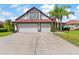 Exterior view of home featuring a spacious driveway leading to an attached two-car garage at 5737 Wynstone Ln, Zephyrhills, FL 33541