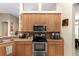 Well-equipped kitchen featuring stainless steel appliances, wooden cabinets, and granite countertops at 5737 Wynstone Ln, Zephyrhills, FL 33541