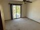 Bedroom with balcony features ceiling fan, and a sliding glass door out to the balcony at 5956 Seaside Dr, New Port Richey, FL 34652