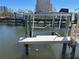 Modern boat lift with wood dock and beautiful waterfront views of nearby condominiums and boat docks at 5956 Seaside Dr, New Port Richey, FL 34652