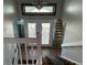 Entryway with patterned glass doors, overhead transom, tiled foyer, wood stairs and mirrors at 5956 Seaside Dr, New Port Richey, FL 34652