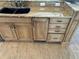 Kitchen base cabinet with wooden cabinetry, granite countertops, a black sink, and stainless steel appliances at 5956 Seaside Dr, New Port Richey, FL 34652