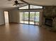 Open floor plan with vaulted ceiling, stone fireplace, and sliding glass doors leading to the balcony at 5956 Seaside Dr, New Port Richey, FL 34652