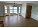 Bright living room features wood-look flooring and a chandelier over the dining area near large bright windows at 5956 Seaside Dr, New Port Richey, FL 34652