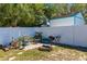 Landscaped backyard with seating area, fire pit, and white privacy fence at 6244 Warren Ave, New Port Richey, FL 34653