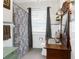 Charming bathroom featuring vintage vanity, patterned shower curtain, and hexagonal tile floor at 6244 Warren Ave, New Port Richey, FL 34653