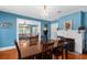 Dining room with blue walls, fireplace, chandelier, hardwood floors, and an open floor plan at 6244 Warren Ave, New Port Richey, FL 34653
