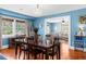 Dining room with blue walls, wood table, chandelier, hardwood floors, and open to the living room at 6244 Warren Ave, New Port Richey, FL 34653