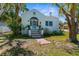 Charming home featuring a unique tiled staircase, arched entryway, and well-maintained front yard landscaping at 6244 Warren Ave, New Port Richey, FL 34653