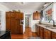 Charming kitchen featuring dark wood cabinets, stainless steel sink, and hardwood floors at 6244 Warren Ave, New Port Richey, FL 34653
