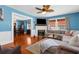 Bright living room with fireplace, ceiling fan, hardwood floors, and a comfortable sectional sofa at 6244 Warren Ave, New Port Richey, FL 34653