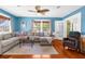 Bright living room with hardwood floors, large sectional sofa, and multiple windows for natural light at 6244 Warren Ave, New Port Richey, FL 34653