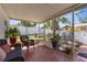 Enclosed patio with patterned tile floor, wicker furniture, and lush garden views at 6244 Warren Ave, New Port Richey, FL 34653