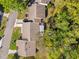 Birds eye view of a residential property, showcasing the roof, landscaping, and surrounding trees at 6652 Brambleleaf Dr, Spring Hill, FL 34606