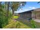 Screened in porch surrounded by a lush green lawn and mature trees providing ample shade at 6652 Brambleleaf Dr, Spring Hill, FL 34606