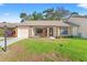 Charming single-story home featuring a well-manicured lawn and a cozy front porch with stone accents at 6652 Brambleleaf Dr, Spring Hill, FL 34606