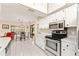 Bright kitchen featuring white cabinetry, stainless steel appliances, and white tile flooring throughout at 6652 Brambleleaf Dr, Spring Hill, FL 34606