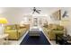 Inviting living room featuring light green sofas, a blue rug, and an open view to the foyer at 6652 Brambleleaf Dr, Spring Hill, FL 34606