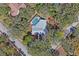 Aerial view of a home featuring a screened in pool with mature landscaping on a corner lot at 7256 Royal Oak Dr, Spring Hill, FL 34607