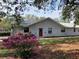 Exterior shot of a home with a red door and lush landscaping, creating a welcoming entrance at 7256 Royal Oak Dr, Spring Hill, FL 34607