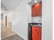 Hallway featuring a wet bar with granite counters, wood cabinets, and a mini-fridge at 7256 Royal Oak Dr, Spring Hill, FL 34607