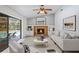 Staged living room with brick fireplace and furniture overlooking outdoor pool at 7256 Royal Oak Dr, Spring Hill, FL 34607