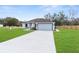 Inviting single-story home with a large driveway and a two-car garage, set on a verdant lawn at 8116 Ridge Rd, Weeki Wachee, FL 34613