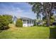 Backyard with mature trees and green grass, offering privacy and a park-like setting at 8121 Casuarina Dr, Port Richey, FL 34668