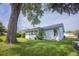 Backyard with mature trees and green grass, offering privacy and a park-like setting at 8121 Casuarina Dr, Port Richey, FL 34668