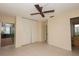 Bright bedroom with tile floor, fan, large closet, and ensuite bathroom at 8121 Casuarina Dr, Port Richey, FL 34668