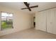 Bedroom with ceiling fan, tile floors, and built in closet at 8121 Casuarina Dr, Port Richey, FL 34668