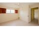 Bright bedroom with neutral tile flooring, ceiling fan, windows and closet at 8121 Casuarina Dr, Port Richey, FL 34668