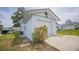 A well-maintained white home with an attached garage and landscaped with blooming flowers at 8121 Casuarina Dr, Port Richey, FL 34668