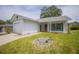Beautiful white single-story home featuring a well-manicured lawn and charming landscaping at 8121 Casuarina Dr, Port Richey, FL 34668